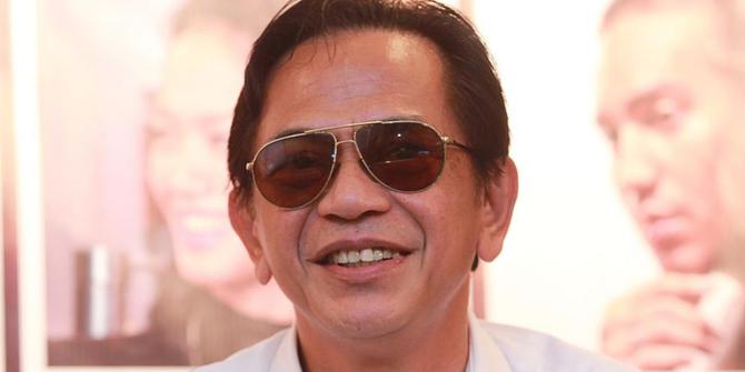 Ray Sahetapy menggunakan kaca mata hitam dan tersenyum